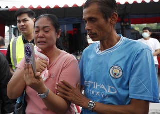 Naruemol Thomglek (L) weeps as she waits for missing family members during a search operation for survivors at the site of a collapsed building following an earthquake in Bangkok
